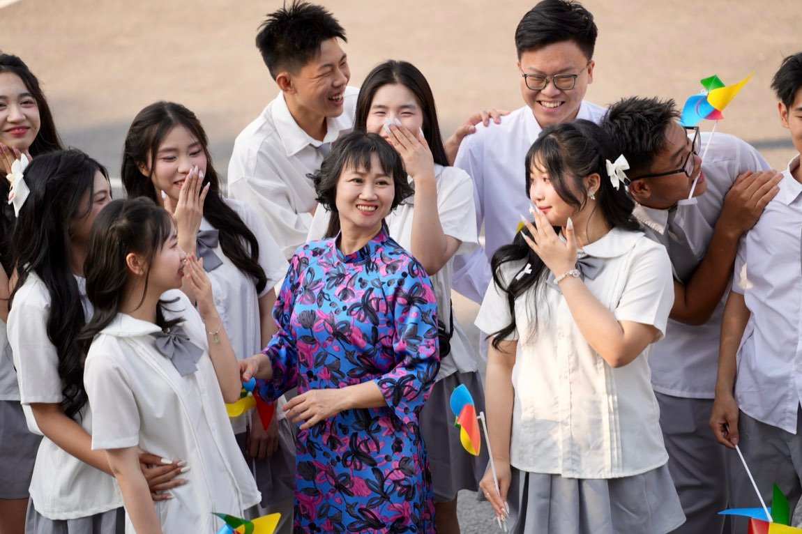 Students laughing candidly around their teacher