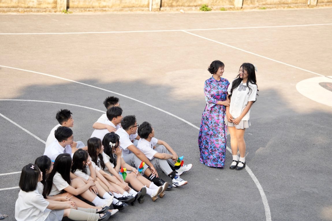 Teacher holding hands with one student while the class watches