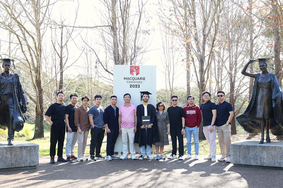 Large family group at the university sign flanked by statues